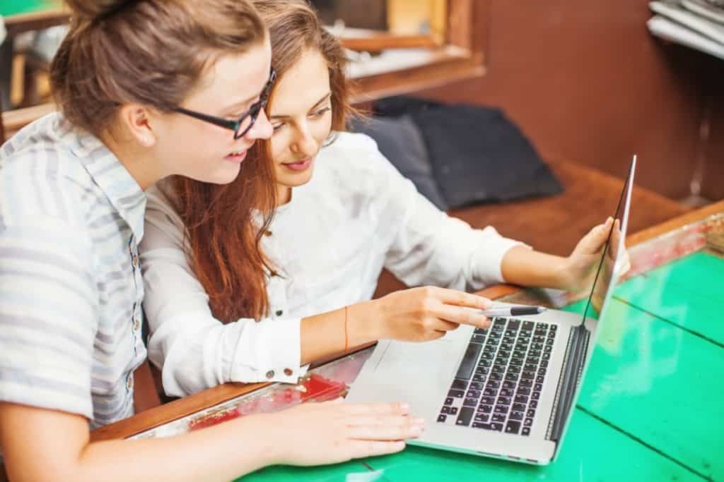 An image of two young women looking at a computer.