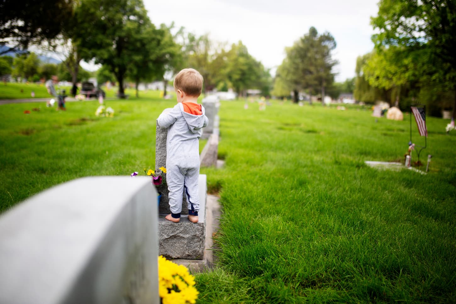 An image of family cleaning gravestones at the cemetery.