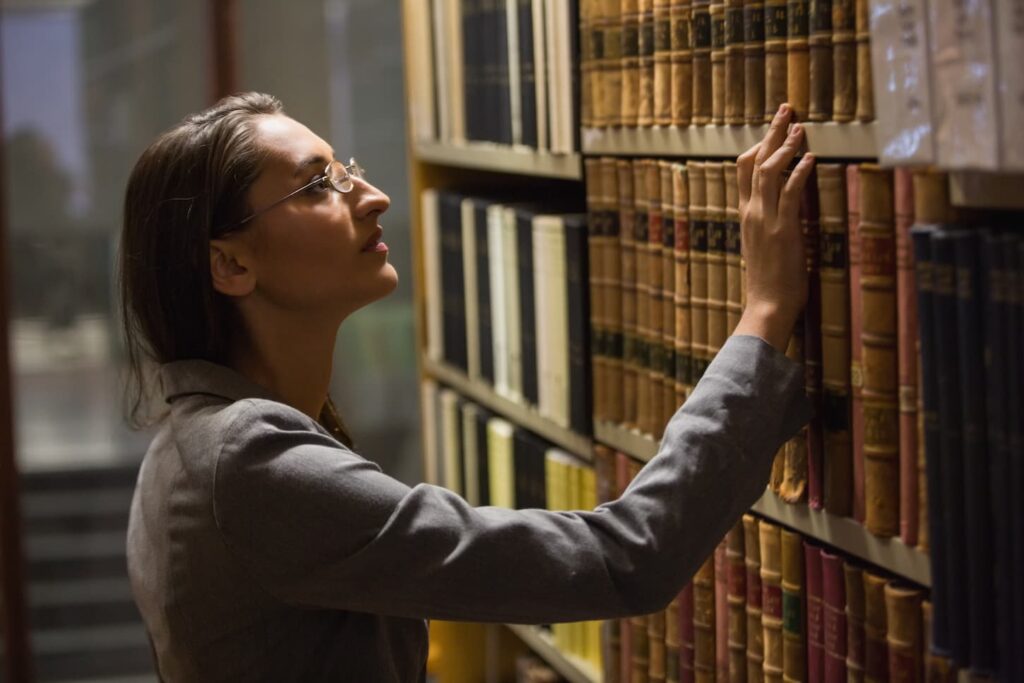An image of a lawyer picking a book in the law library at the university.