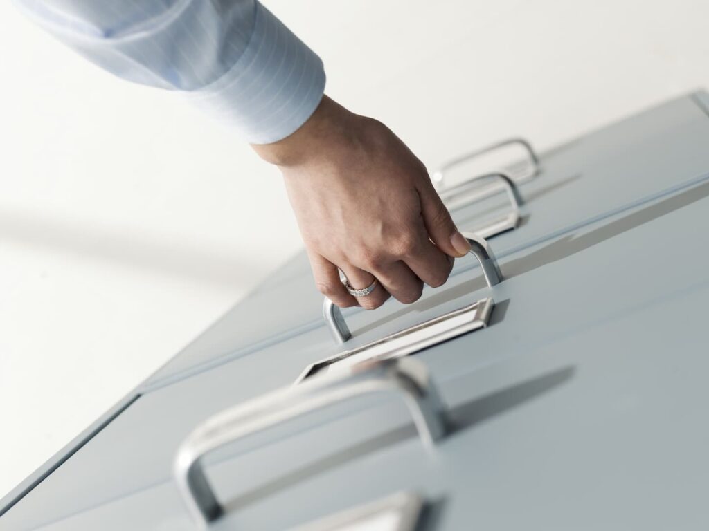 An image of a Secretary searching files in the filing cabinet.