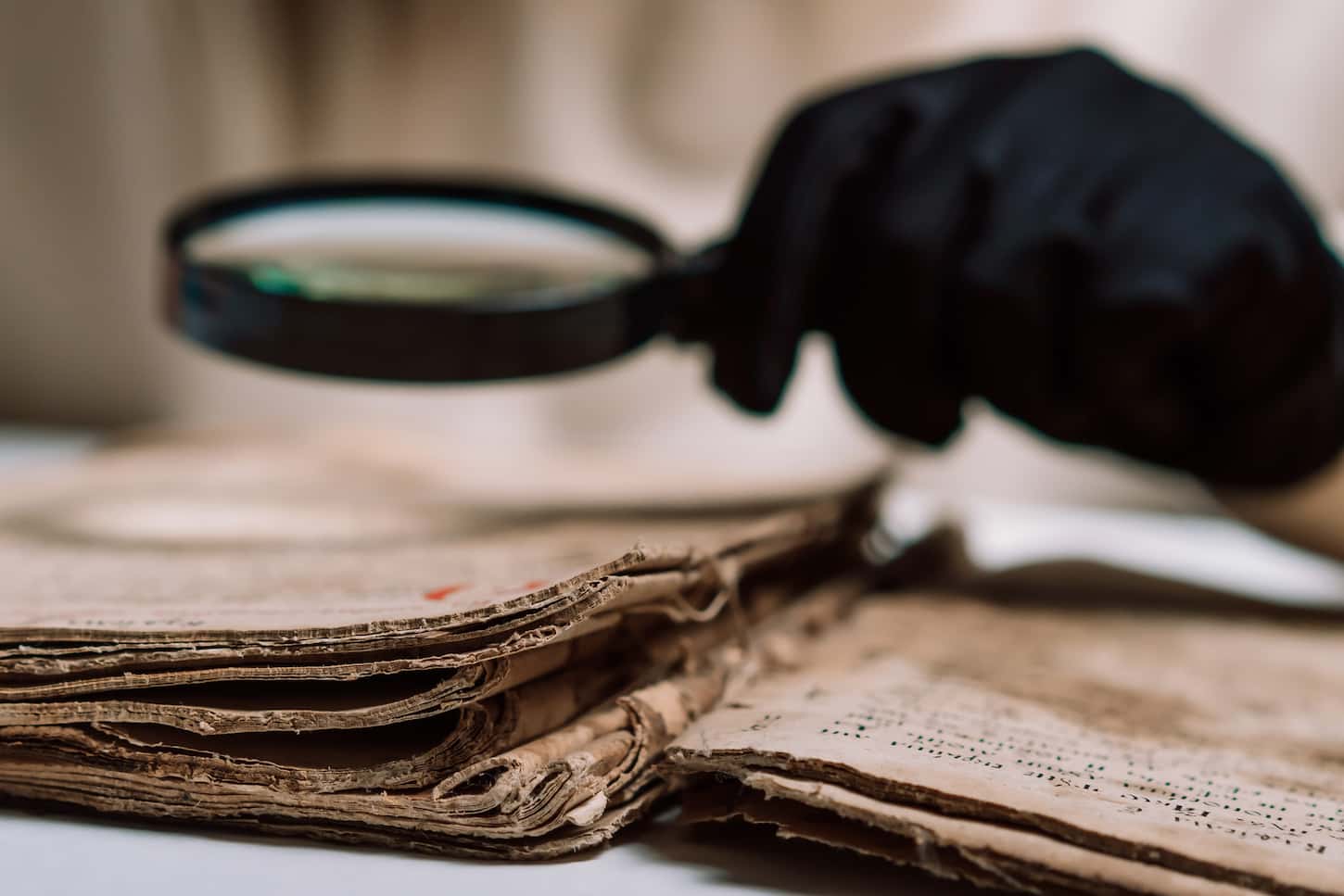An image of a Historian scientist in gloves reading an antique book with a magnifying glass. Translation of religious literature. Manuscript with ancient writings. Treasures of the past. Museum piece.