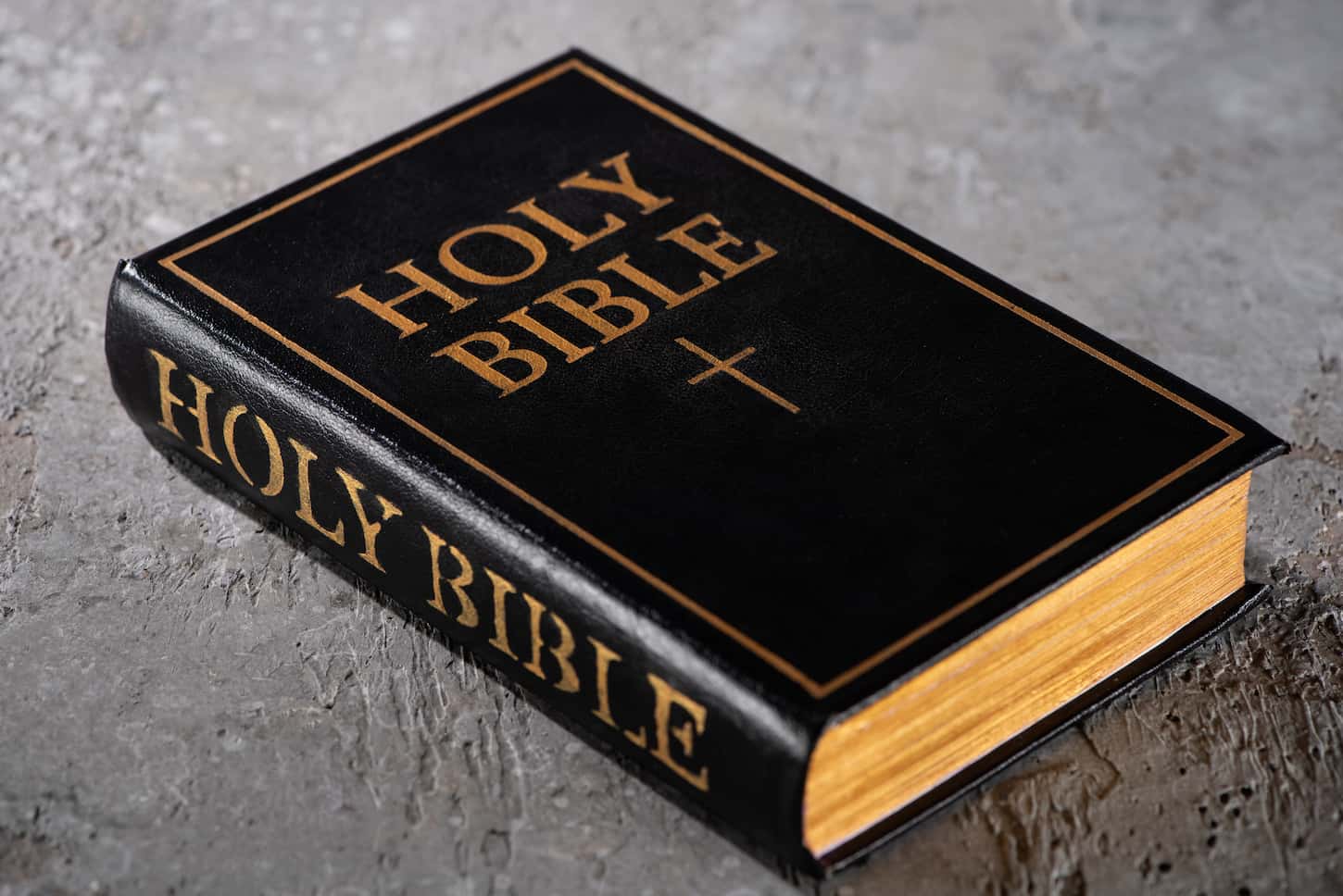 An image of a holy bible on a grey textured surface.