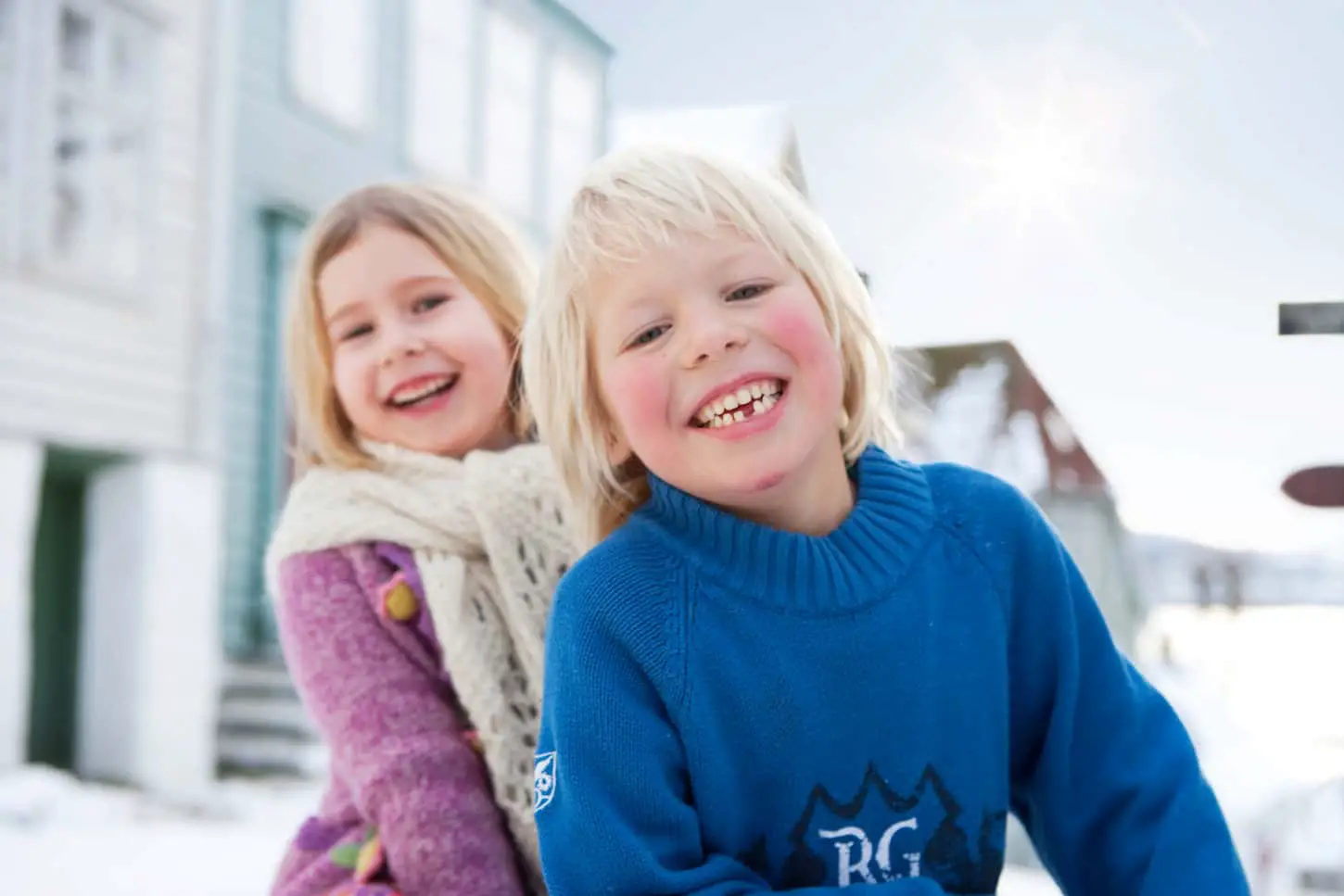 An image of Scandinavian children smiling during the winter season.