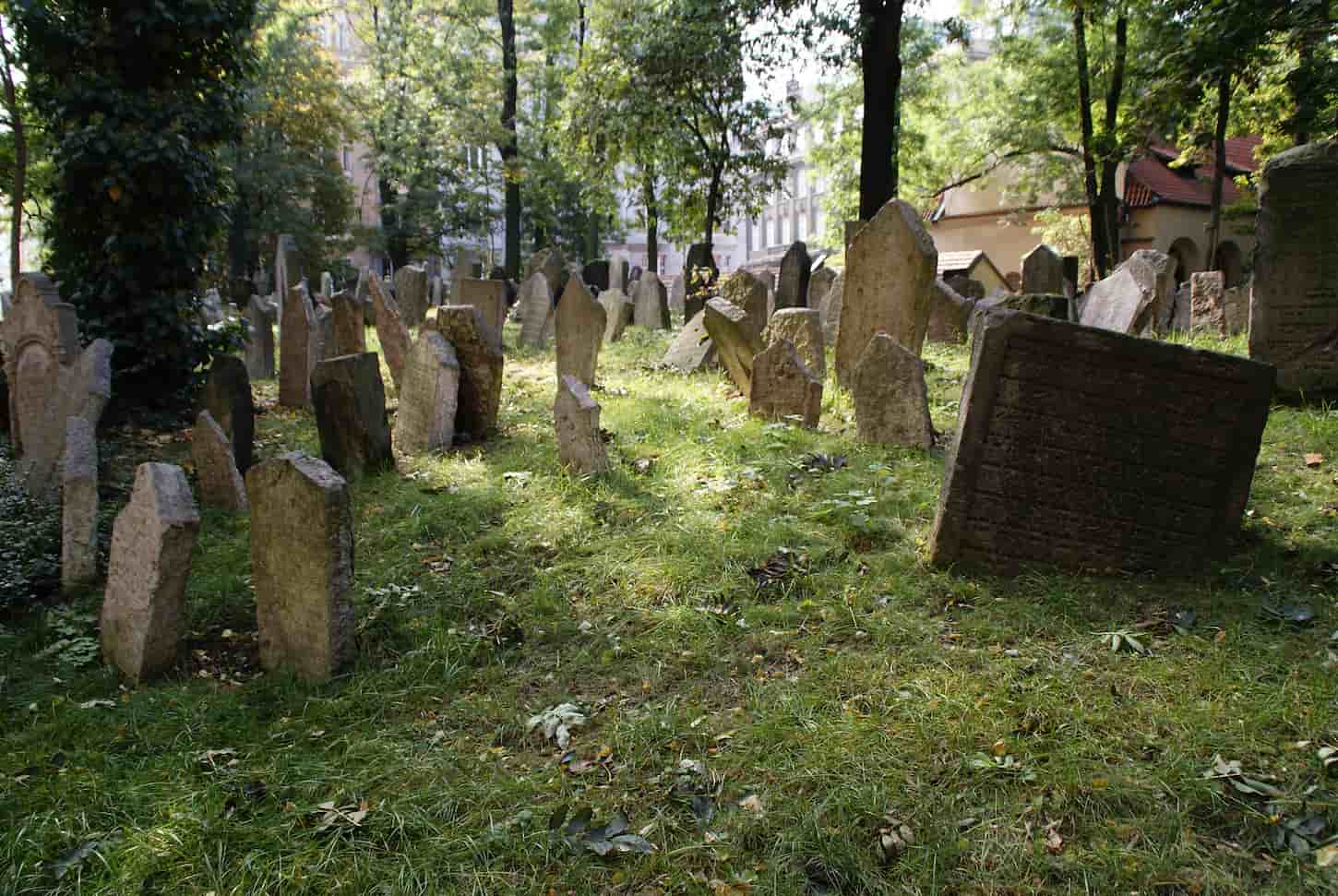 An image of a Historic old Jewish cemetery with rock tombs in Prague and broken monuments by the passage of time.
