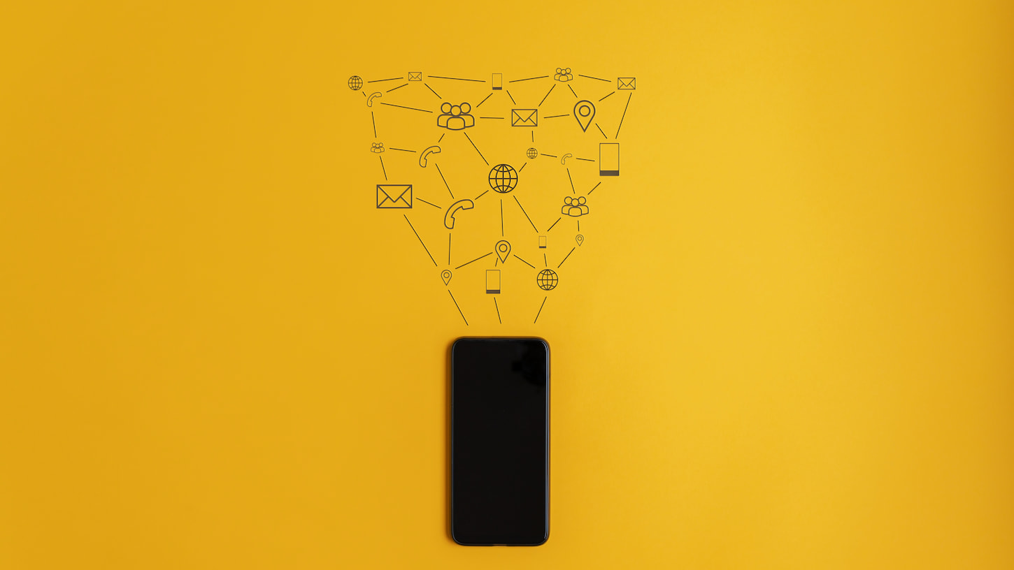 An image of Hand-drawn icons of communication and information coming out of a cell phone in a conceptual image. Over yellow background.