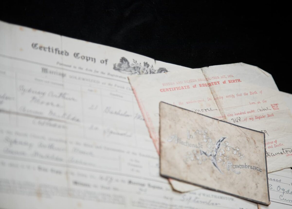 An image of Old family certificates and In Memoriam cards being used to research the family tree.